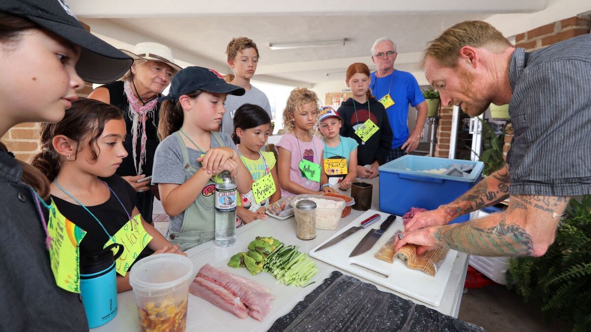 Oceanside chef Davin Waite, at right, demonstrates how to make sushi during his food presentation to children at the Willow Tree Center's sustainable living kids camp this past week in Vista.