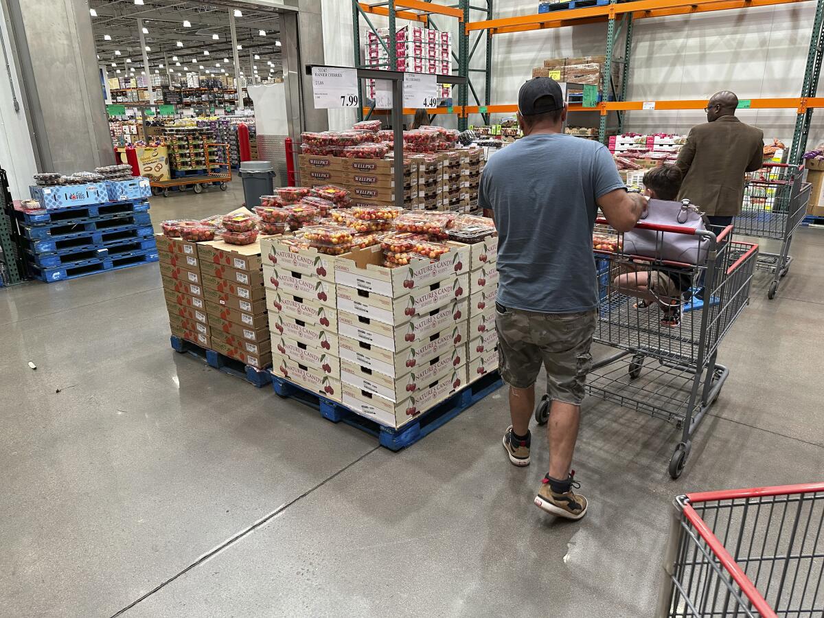 Shoppers peruse a display of Rainer cherries at a Costco warehouse.