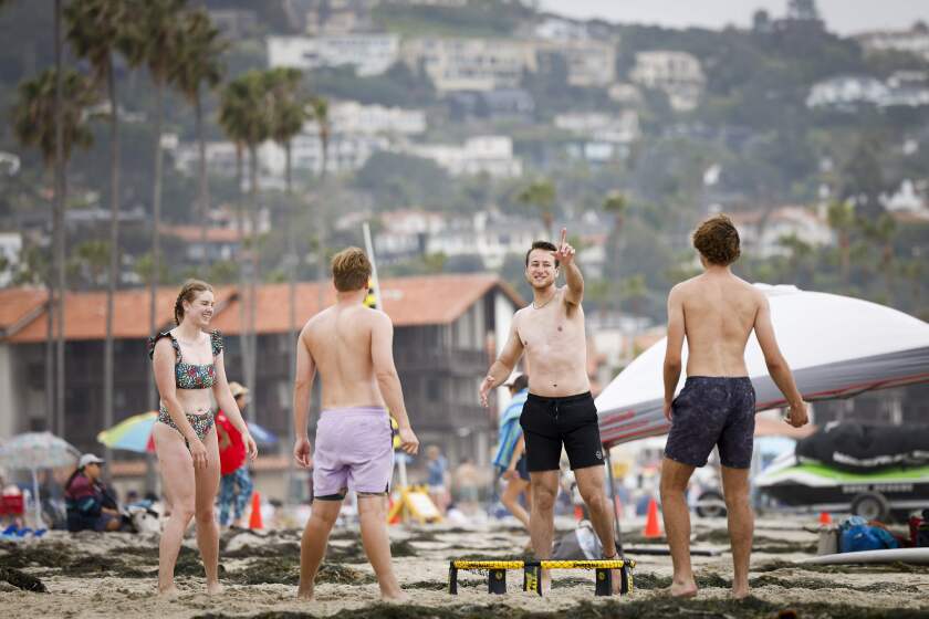 San Diego, CA - May 31: Bryce Brubaker, of Dallas, center, reacts during a game of spike ball at La Jolla Shores on Friday, May 31, 2024 in San Diego, CA. (Meg McLaughlin / The San Diego Union-Tribune)