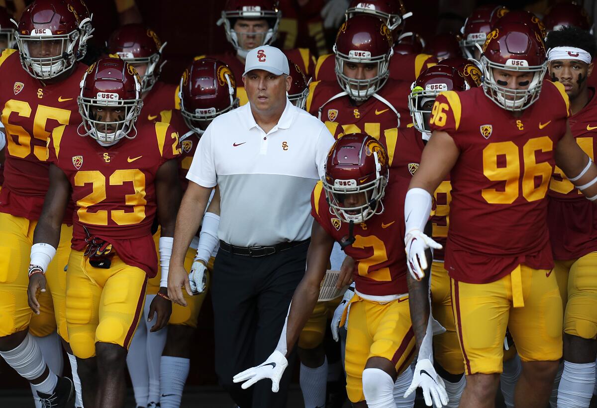 USC coach Clay Helton leads the Trojans onto the field at the Coliseum Sept. 20.