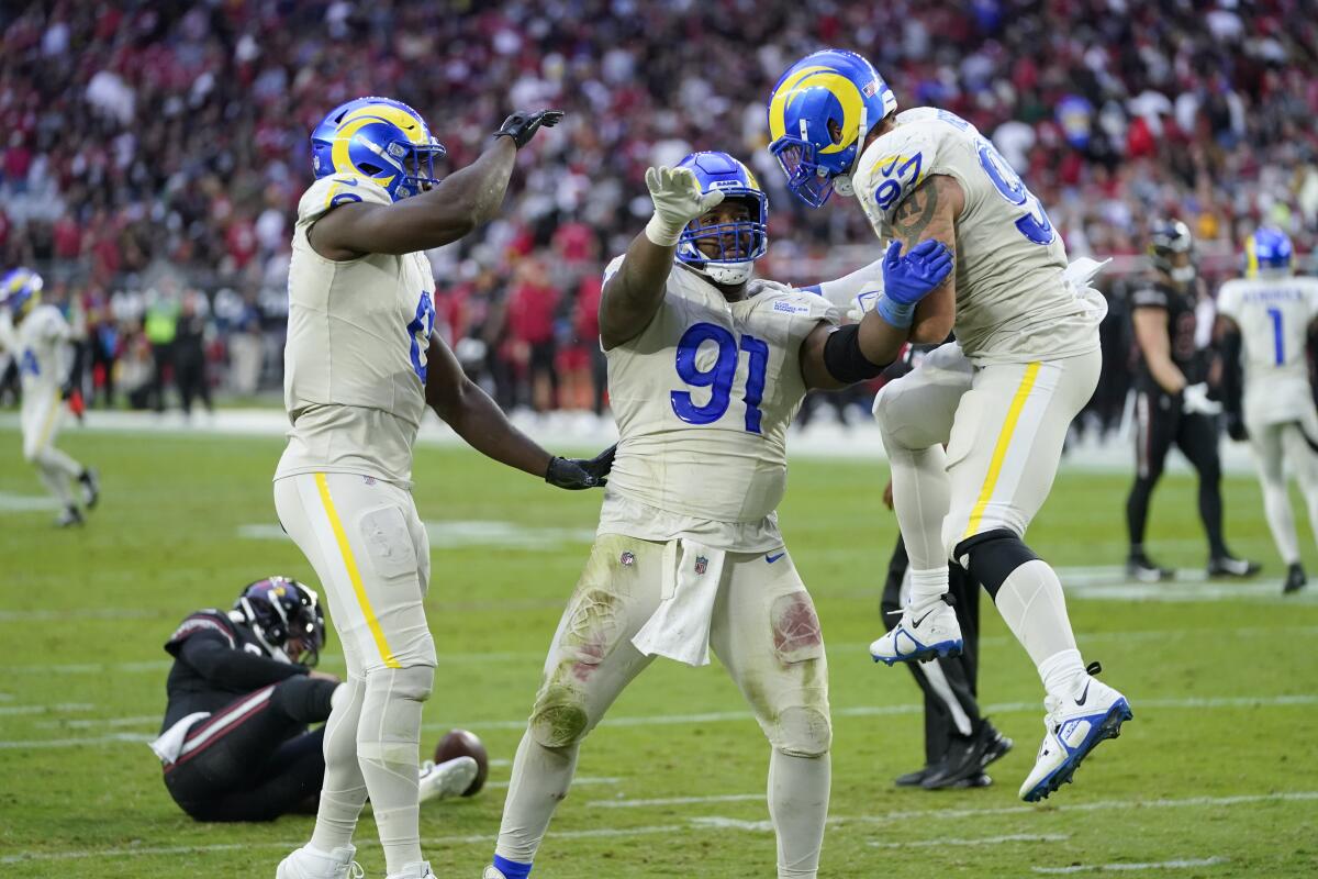 Rams defensive tackle Kobie Turner (91) celebrates a sack with teammates