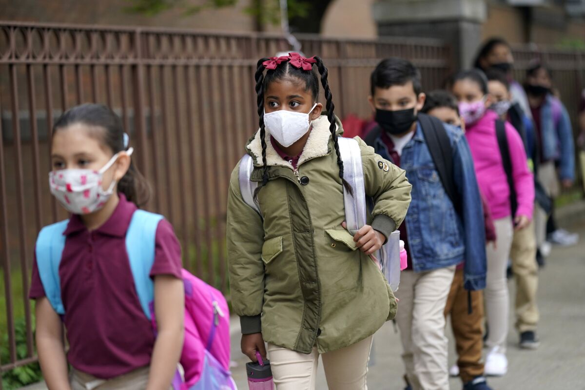 FILE - Students line up to enter Christa McAuliffe School in Jersey City, N.J., April 29, 2021. New Jersey Gov. Phil Murphy will end a statewide mask mandate to protect against COVID-19 in schools and child care centers, his office said Monday, Feb 7, 2022. (AP Photo/Seth Wenig, File)