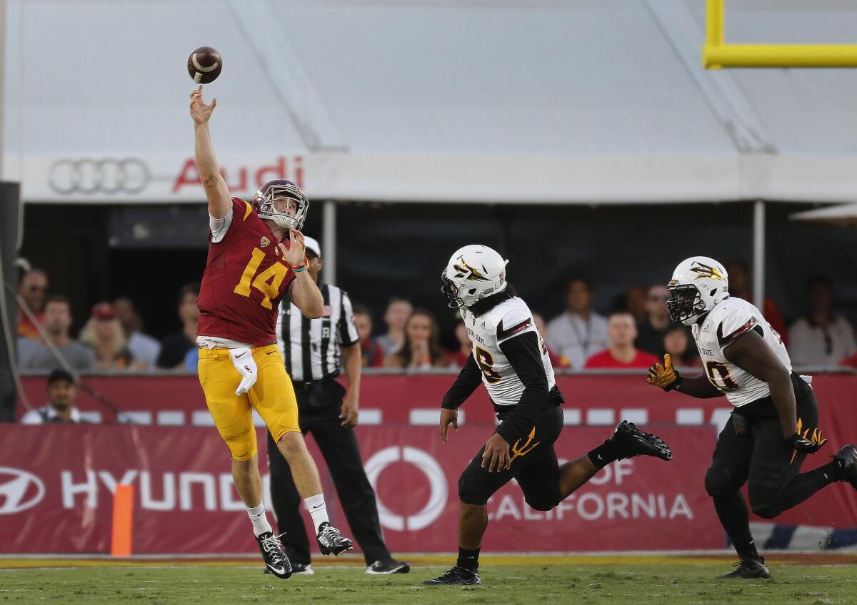 USC quarterback Sam Darnold throws a pass as Arizona State defenders approach in the first half.