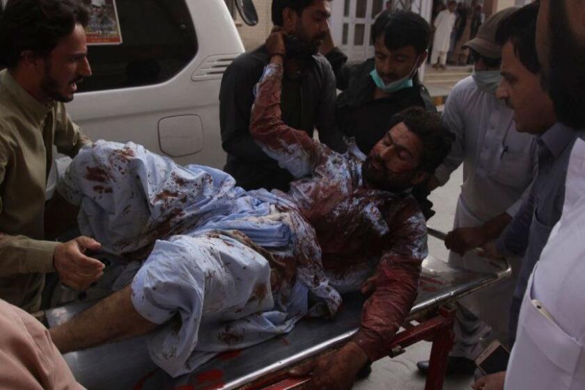 People rush an injured person to a hospital in Quetta, Pakistan, Friday, July 13, 2018. Underscoring the security threat, two bombs exploded Friday killing many people in the latest election related violence to hit Pakistan. The first bomb that killed four people exploded in northwest Pakistan near the election rally of a senior politician from an Islamist party who is running for parliament from the northwestern town of Bannu. (AP Photo/Arshad Butt)