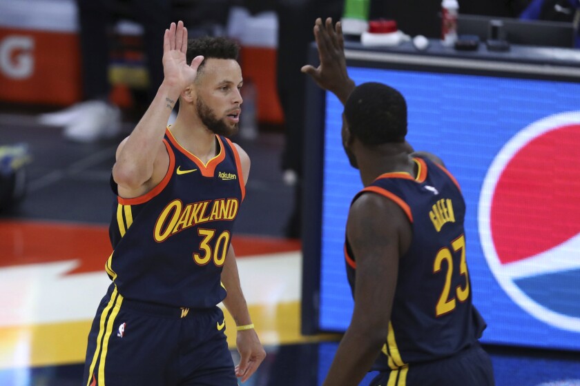 Golden State Warriors guard Stephen Curry is congratulated by Draymond Green after making a basket against the Houston Rockets during the second half of an NBA basketball game in San Francisco, Saturday, April 10, 2021. (AP Photo/Jed Jacobsohn)