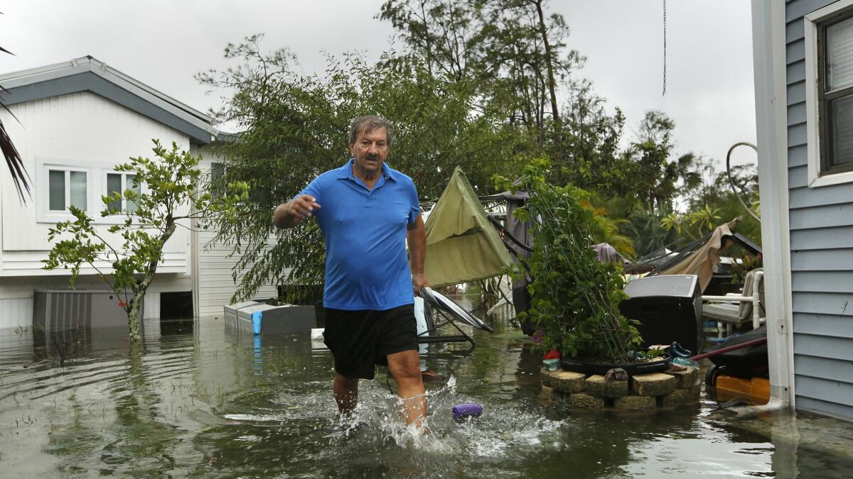 John Krowzow, 74, wades in floodwater to check out his homes in Corkscrew Woodlands, a park with 640 senior mobile home units in Estero, Fla.
