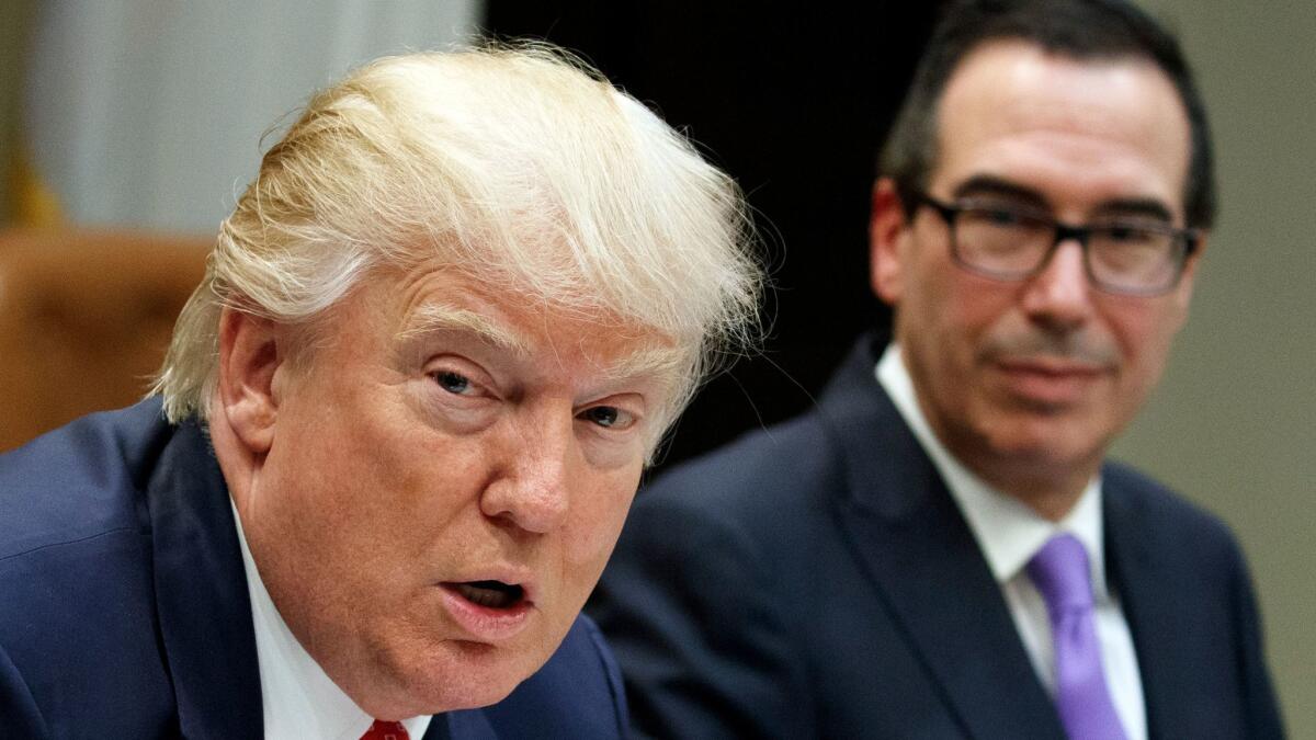 Treasury Secretary Steven Mnuchin listens at right as President Donald Trump speaks in the Roosevelt Room of the White House on Feb. 22.