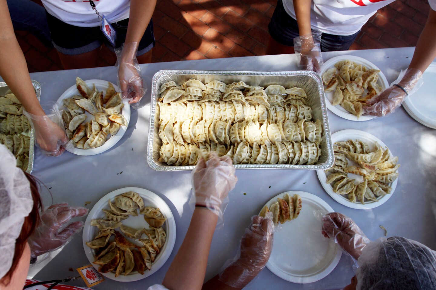 Volunteers prepare gyoza plates before the Day-Lee Foods World Gyoza Eating Championship.