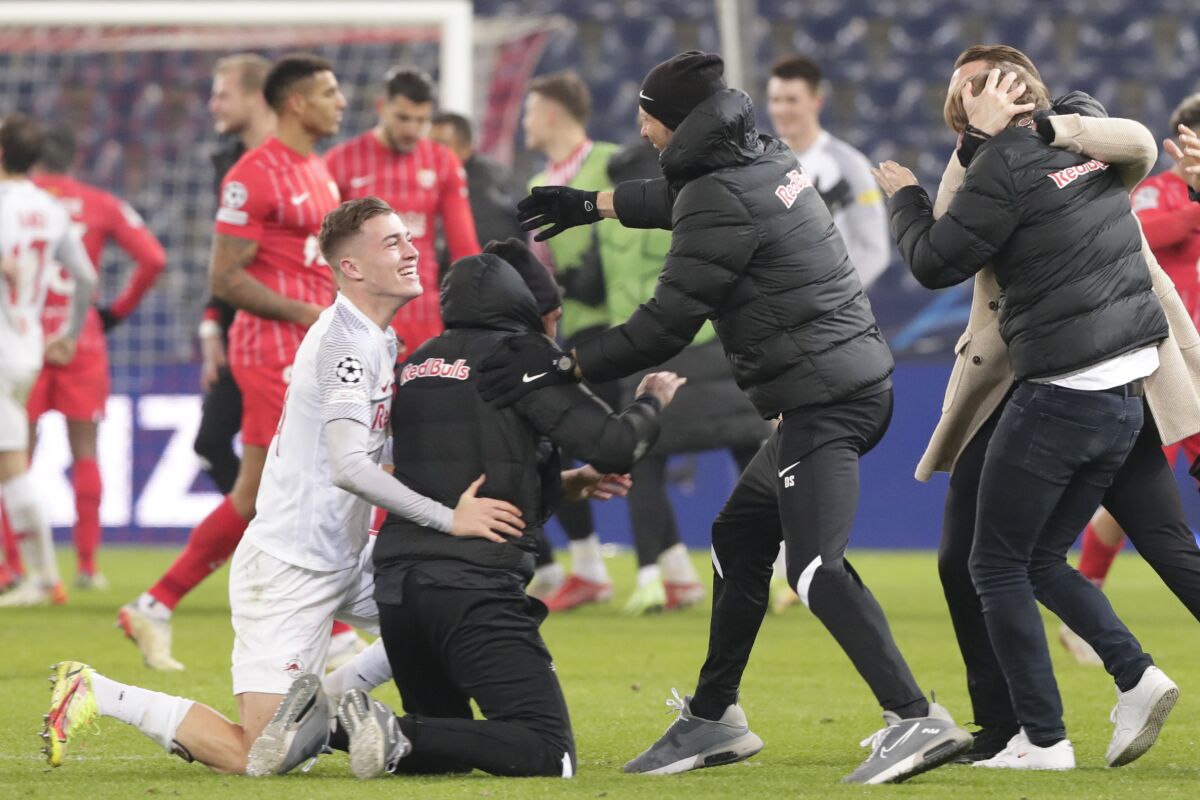 Salzburg players celebrate after defeating Sevilla during the Champions League Group G soccer match between RB Salzburg and Sevilla at the Red Bull Arena in Salzburg, Austria, Wednesday, Dec. 8, 2021. (AP Photo/Lisa Leutner)