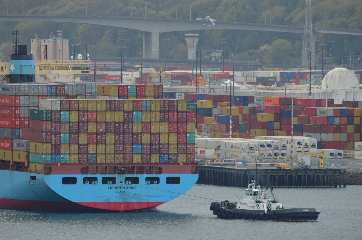 A tugboat pulls a cargo ship.