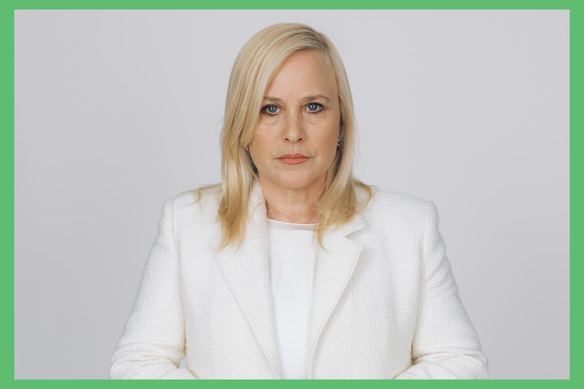 Patricia Arquette in a white jacket and blouse against a white background.