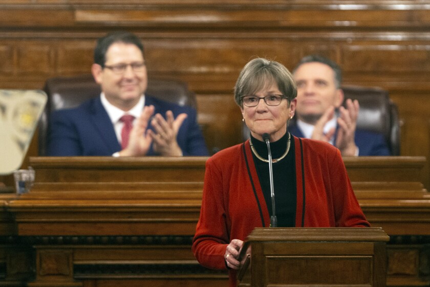 Gov. Laura Kelly is applauded as she begins addressing the Kansas Legislature for the annual State of the State, Tuesday, Jan. 11, 2022, in Topeka, Kan. Democratic and Republican governors are taking vastly different approaches to addressing the ongoing pandemic in their state of the state speeches. (Evert Nelson/The Topeka Capital-Journal via AP)