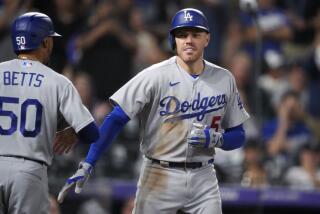 Los Angeles Dodgers' Mookie Betts, left, congratulates Freddie Freeman for a three-run home run off Colorado Rockies relief pitcher Justin Lawrence during the eighth inning of a baseball game Wednesday, Sept. 27, 2023, in Denver. (AP Photo/David Zalubowski)