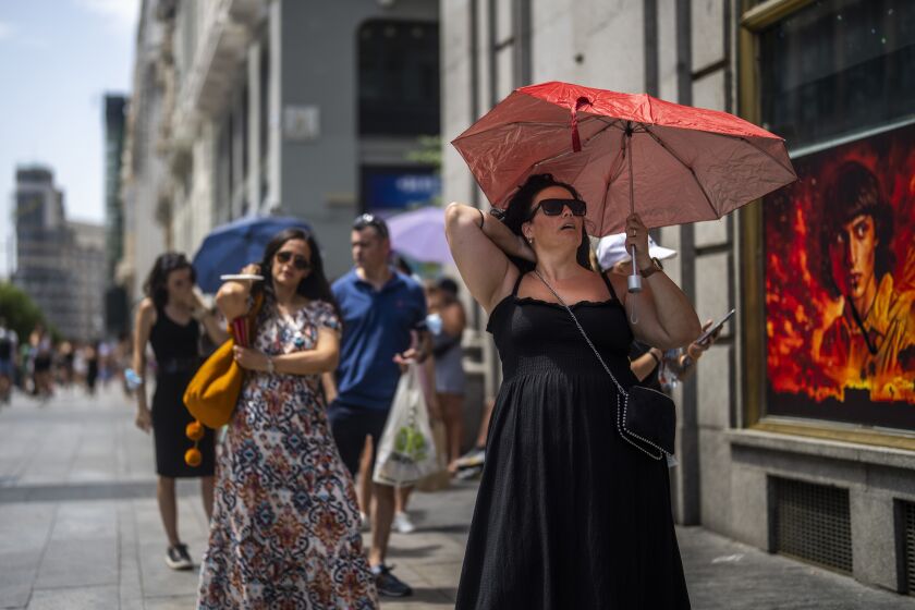 FILE - A woman holds an umbrella to shelter from the sun during a hot sunny day in Madrid, Spain, on July 18, 2022. Spain registered its hottest spring on record this year, and its second driest ever, the state meteorological agency said Wednesday, June 7, 2023. (AP Photo/Manu Fernandez, File)