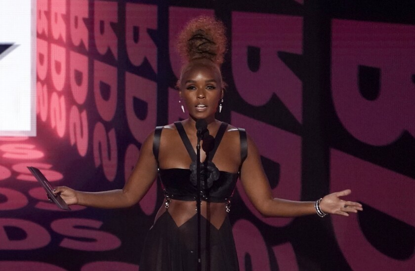 A person standing on stage with arms outstretched