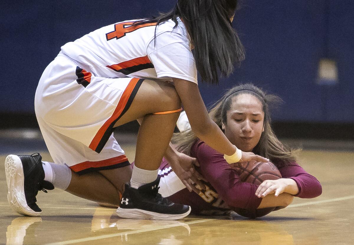 Los Amigos' Vanessa Robledo, left, battles for a loose ball against Estancia's Pamela Cabezaz in a Hawk Holiday Classic game on Wednesday at Liberty Christian School.