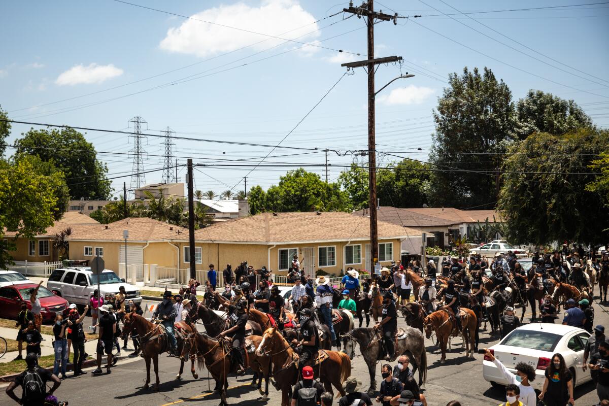 The Compton Cowboys ride down South Tamarind Avenue, along with protesters, during the Compton Peace Ride.