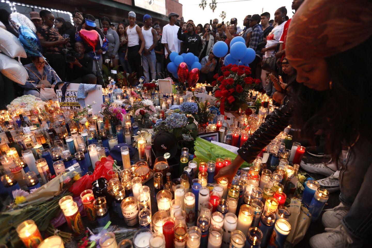 Fans of rapper Nipsey Hussle pay tribue to the slain star in the parking lot of his Marathon Clothing store in South Los Angeles on Monday.