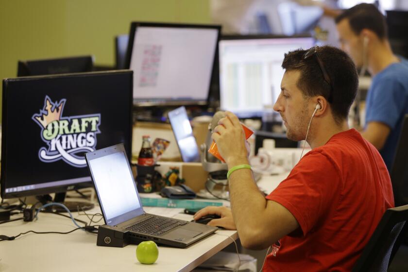 Devlin D'Zmura, a tending news manager at daily fantasy sports company DraftKings, works on his laptop at the company's offices in Boston.
