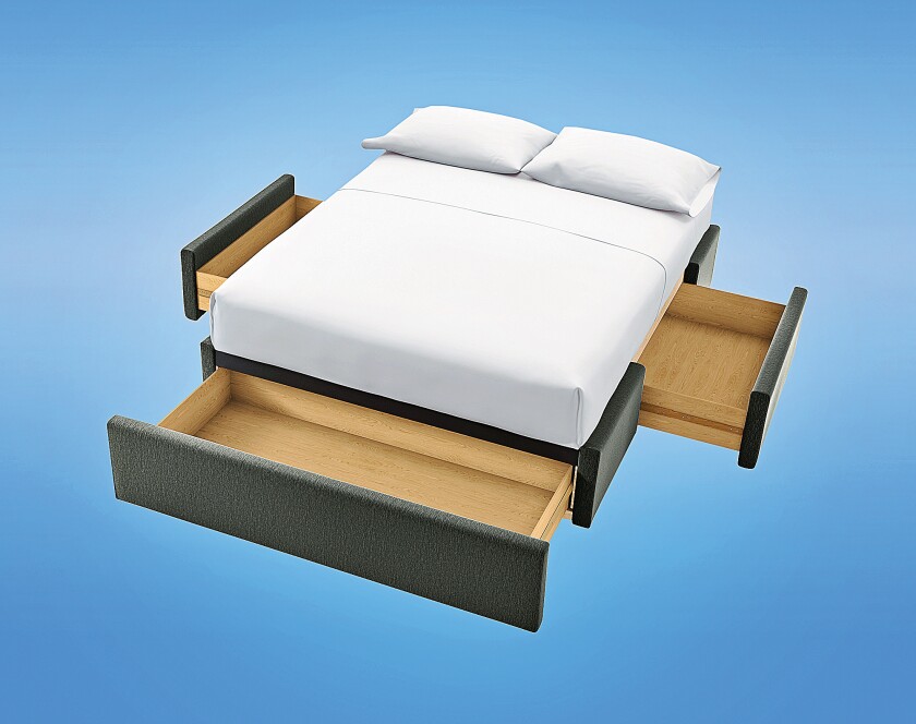A queensize platform bed has storage in the base. A big drawer pulls out at the foot of the bed, with a drawer on each side.