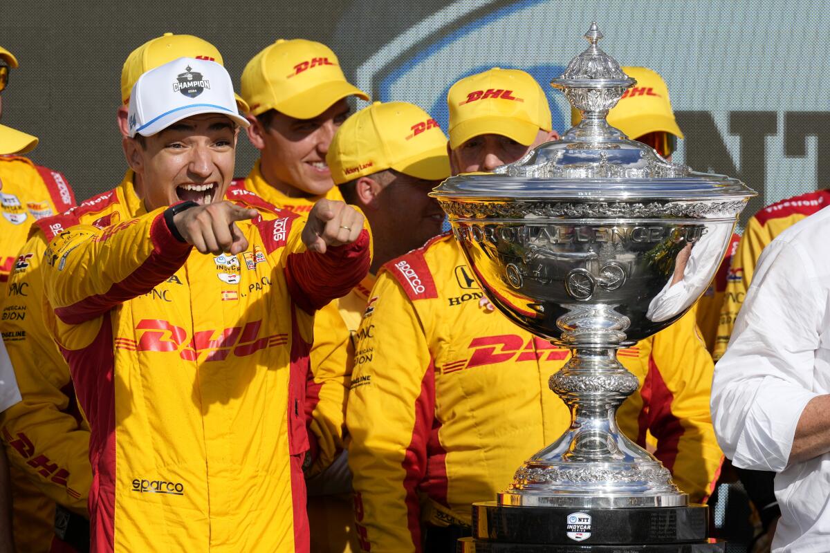 Alex Palou, left, celebrates after winning his third IndyCar championship in four years on Sunday.