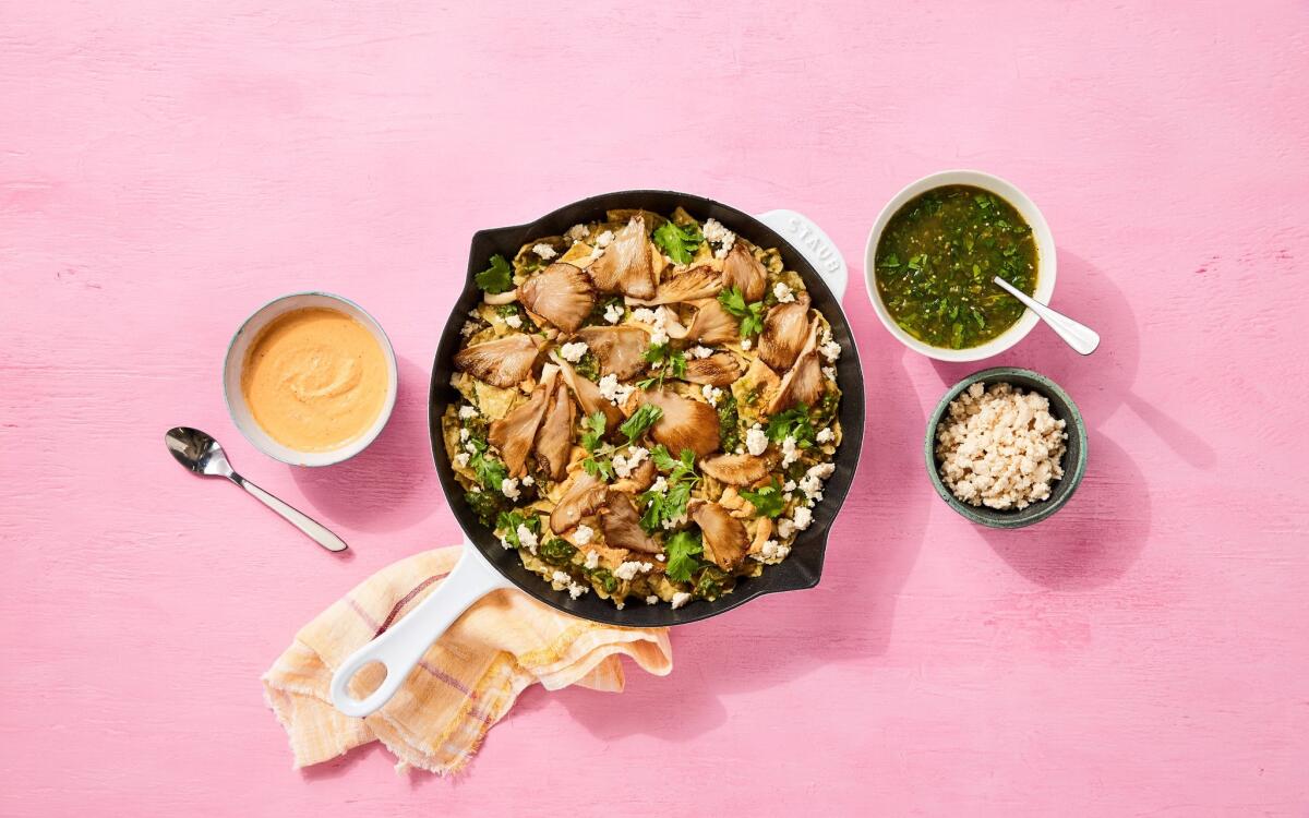 A pot of vegan chilaquiles with smaller dishes of queso and salsa.