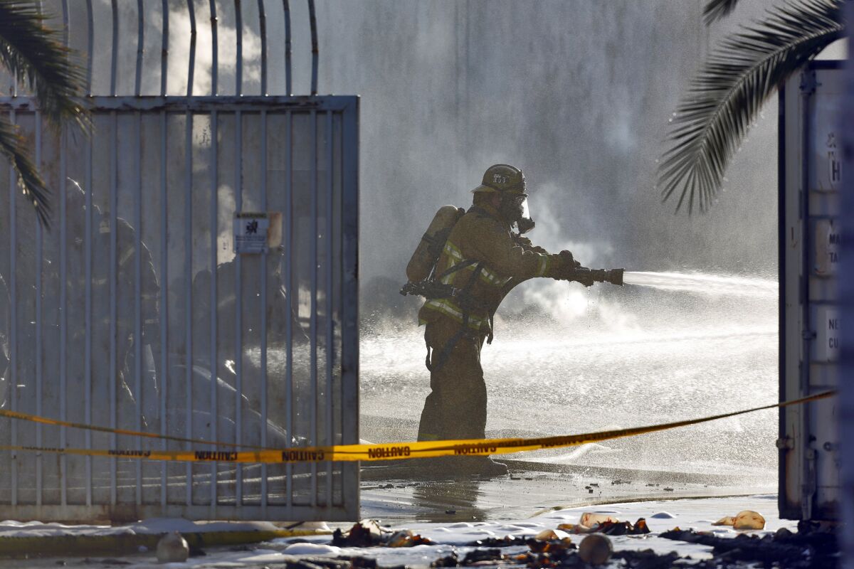 Firefighter shoots water Wednesday at a fire at a Santa Ana warehouse.