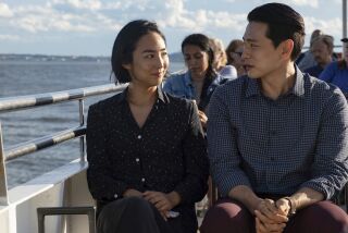 This image released by A24 shows Greta Lee, left, and Teo Yoo in a scene from "Past Lives." (Jon Pack/A24 via AP)