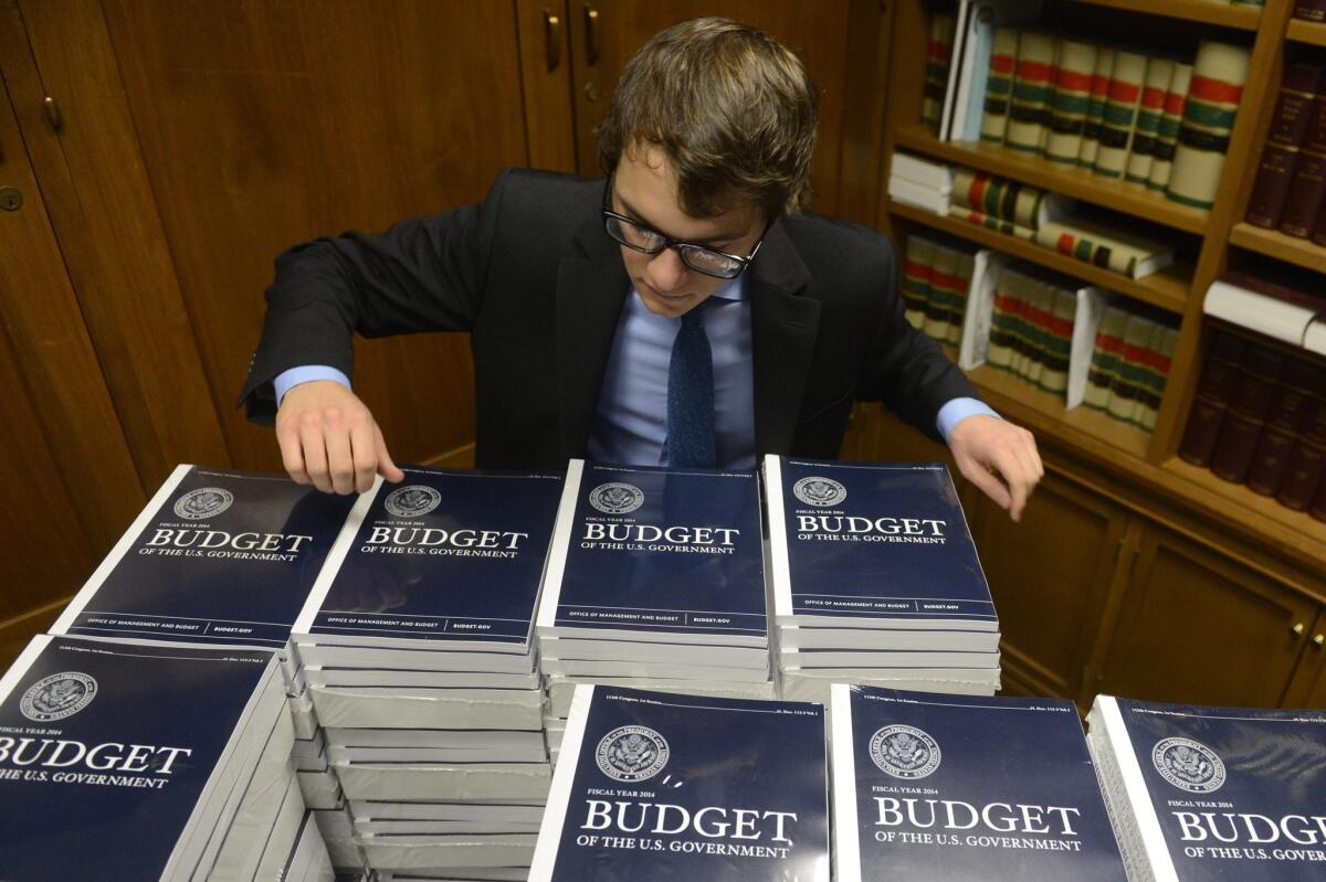 A staffer with the U.S. Senate Budget Committee distributes copies of President Obama's FY2014 budget to Congressional staff members, on Capitol Hill in Washington, D.C.