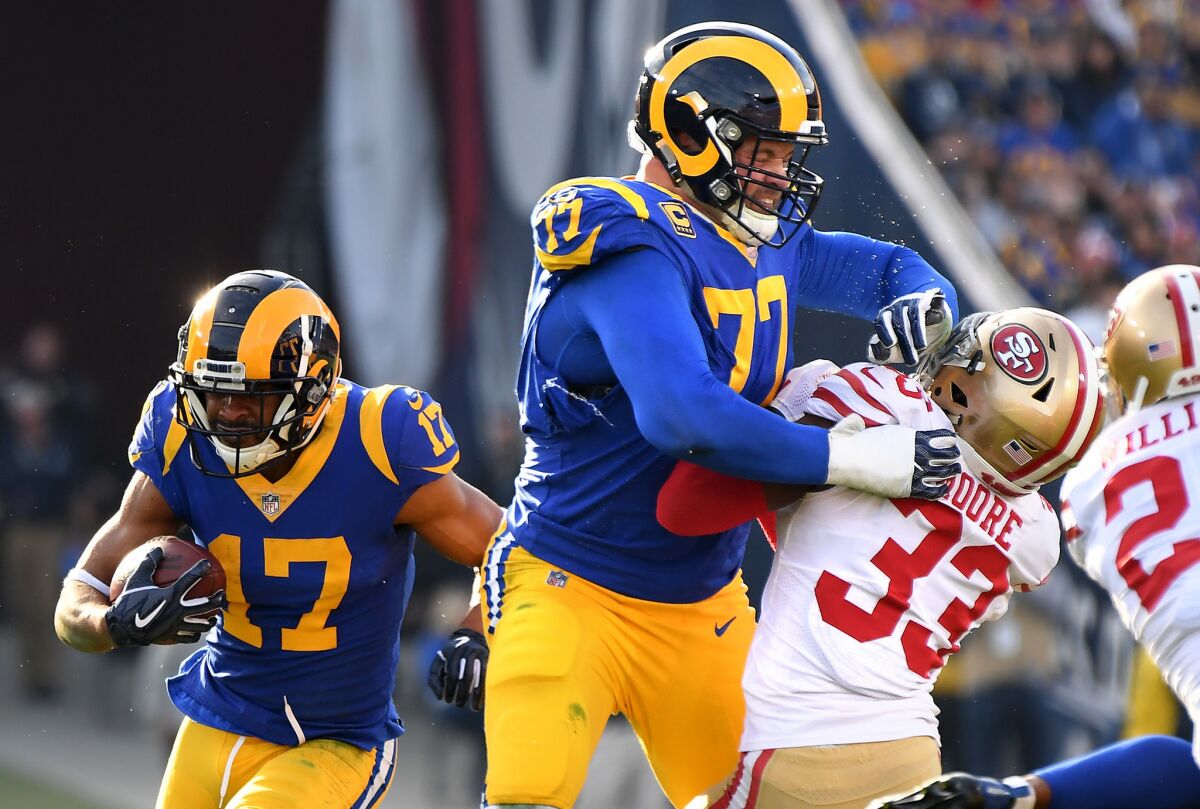Rams tackle Andrew Whitworth (77) provides a block for receiver Robert Woods (17) during a game against the 49ers and Tarvarius Moore (33).