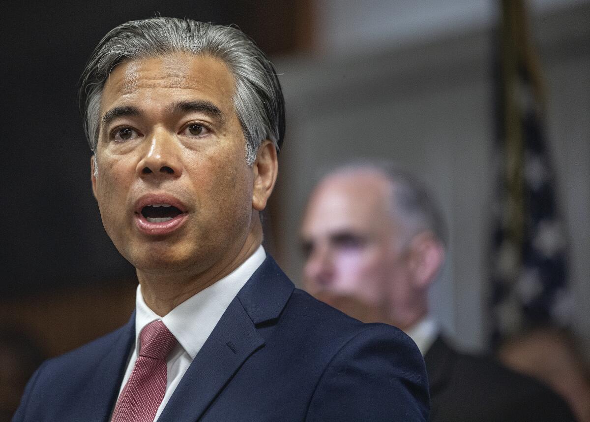 In a head-and-shoulders frame, a man in suit and tie speaks.