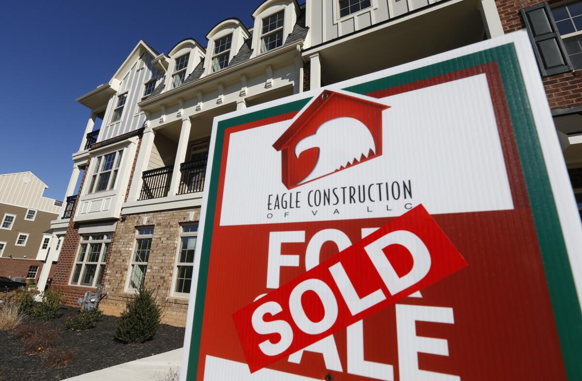 A sign with a sold sticker is posted in front of a row of new townhohuses in Richmond, Va., on Jan. 8.
