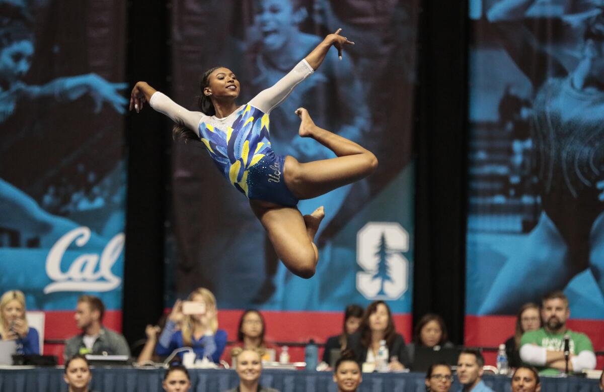 UCLA gymnast Nia Dennis leaps into the air during her floor routine at the Collegiate Challenge meet at the Anaheim Convention center in January.