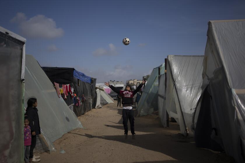 Palestinians displaced by the Israeli ground offensive on the Gaza Strip play at the makeshift tent camp in Rafah on Tuesday, Jan. 23, 2024. (AP Photo/Fatima Shbair)