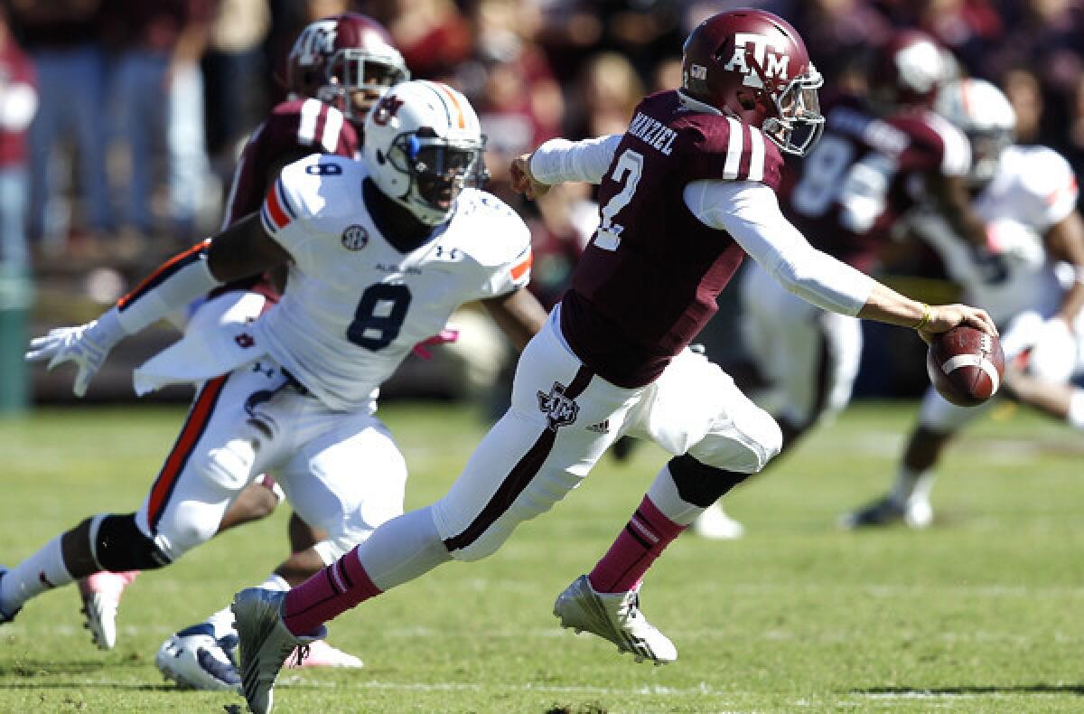 Texas A&M quarterback Johnny Manziel avoids a tackle attempt by Auburn linebacker Cassanova McKinzy (8) in the first quarter Saturday.