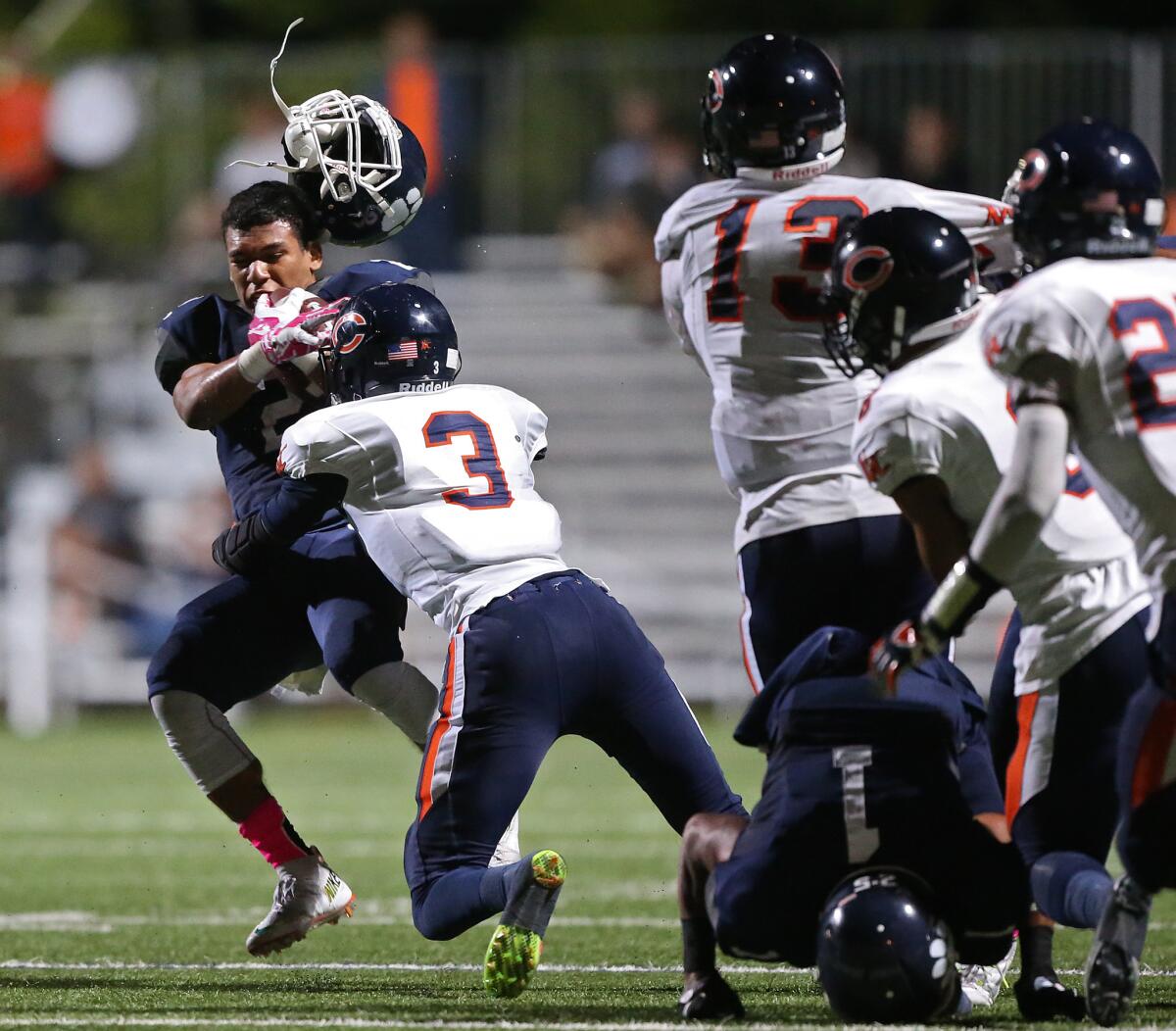 Chaminade defensive back Diamond Harrell knocks the helmet off Loyola quarterback Drake Beasley Jr. in the second quarter. Harrell was called for a personal foul penalty.