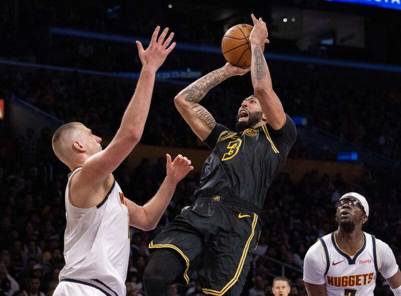 Lakers forveti Anthony Davis, Denver'ın pivotu Nikola Jokic'in üzerinden şutunu çekiyor.