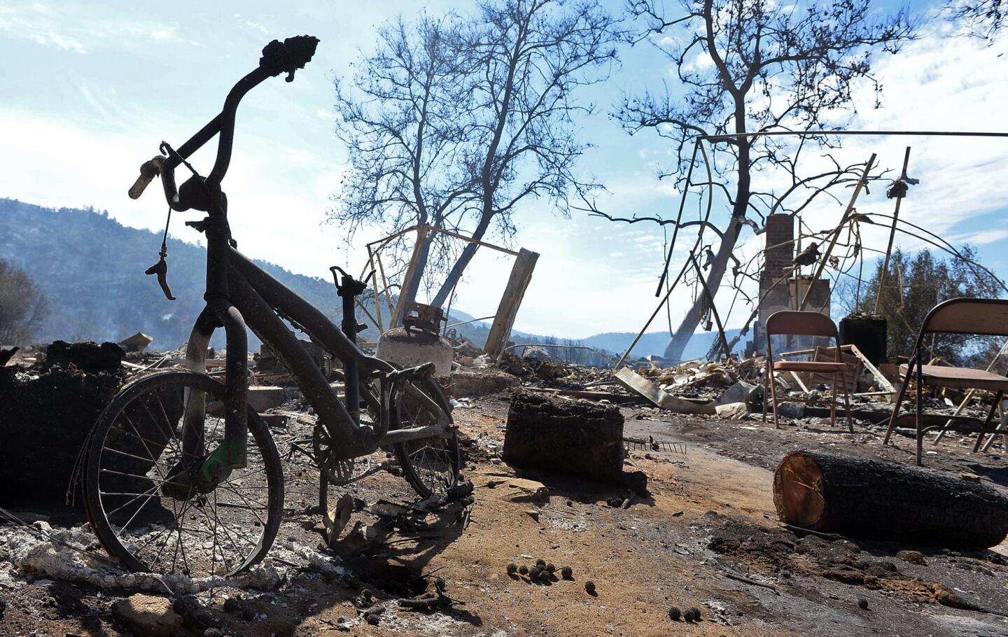 A child's bike sits among the ruins of a burned home destroyed in a wildfire along Highway 41 outside Oakhurst, Calif.