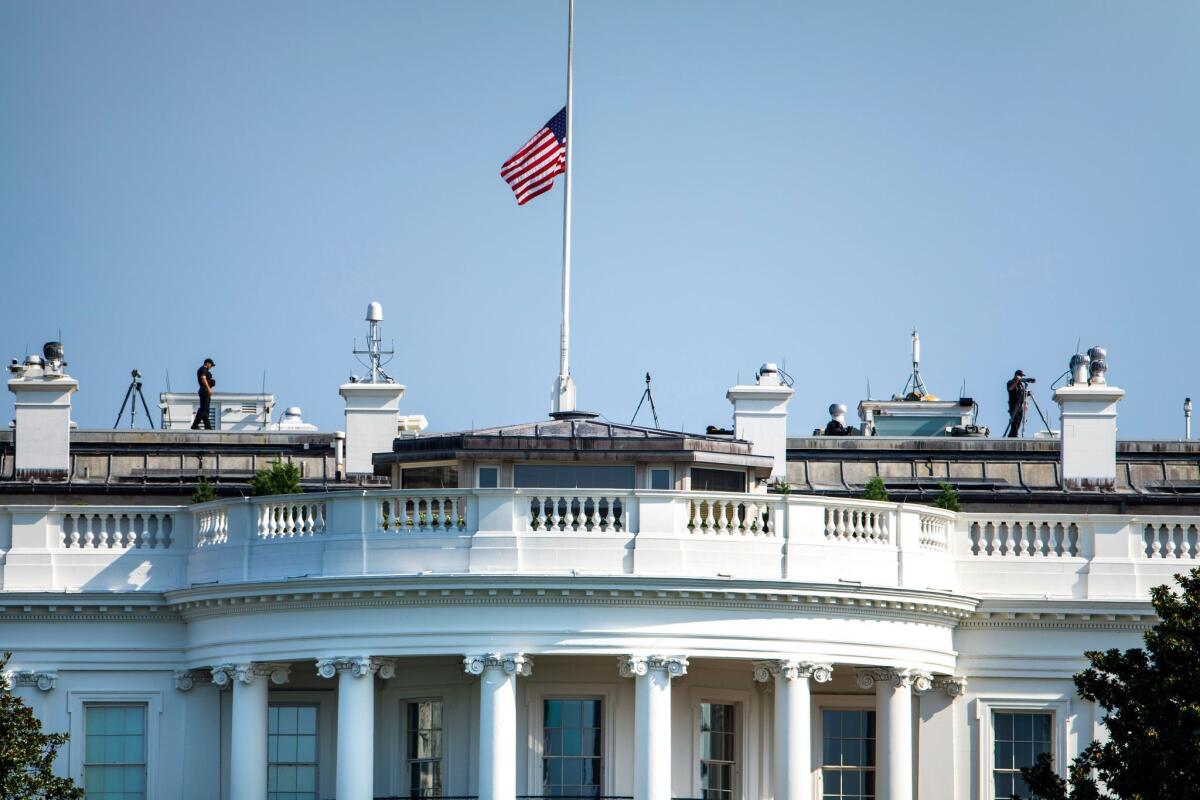 The U.S. flag flies at half-staff in honor of Sen. John McCain at the White House on Sunday.