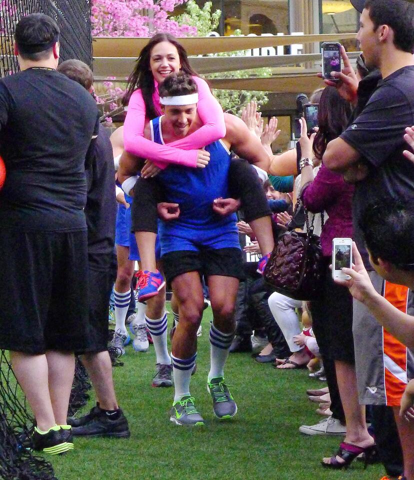 A bachelor on the blue team carries Desiree Hartsock, the bachelorette, on a victory lap for a recording of the new season of the Bachelorette at the Americana at Brand where two teams of bachelors competed in three rounds of dodgeball in Glendale on Wednesday, March 20, 2013.