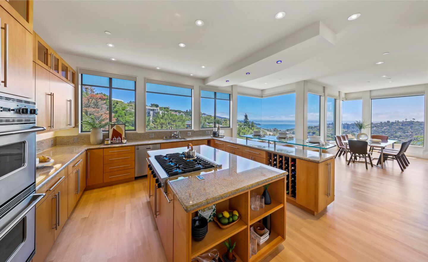 A large island sits in a kitchen with large windows and expansive views.