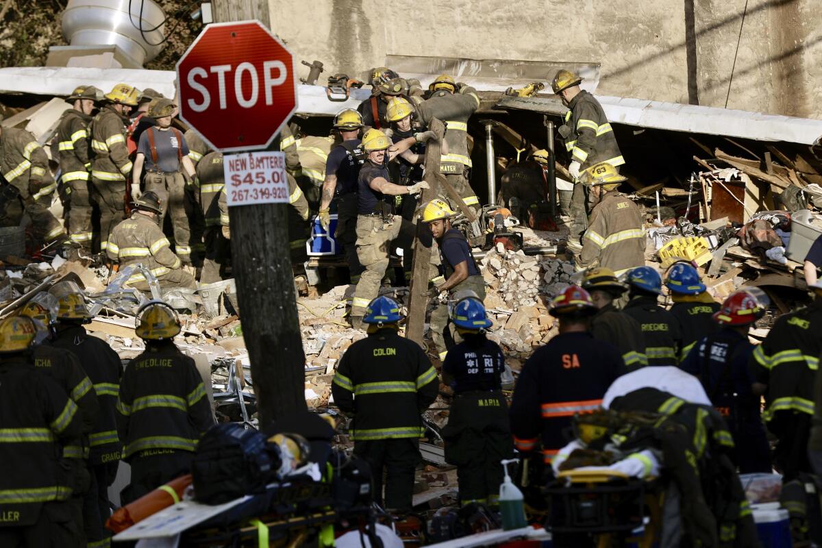 Philadelphia firefighters work to rescue colleagues trapped in a row house collapse on the 300 block of West Indiana, Saturday, June 18, 2022. (Elizabeth Robertson/The Philadelphia Inquirer via AP)
