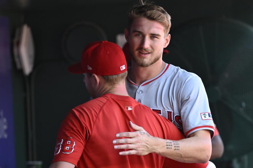 Los Angeles Angels pitcher Davis Daniel, left, embraces starting pitcher Jack Kochanowicz after he was pulled from the game in the eighth inning of a baseball game against the Washington Nationals, Sunday, Aug. 11, 2024, in Washington. (AP Photo/John McDonnell)