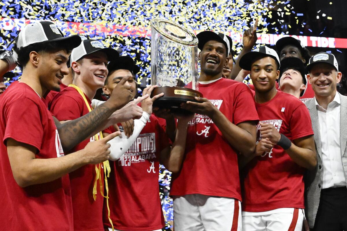 Alabama players pose with the trophy after defeating Texas A&M in the Southeastern Conference tournament final.