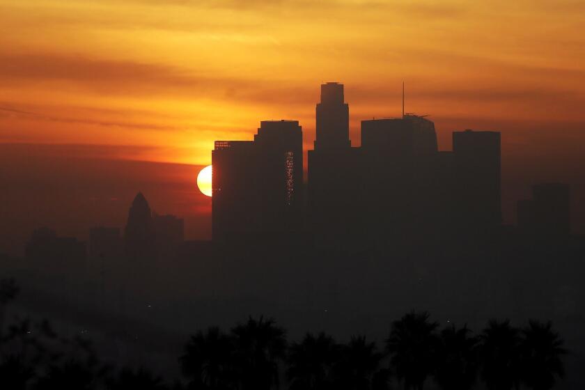 LOS ANGELES, CALIF. DEC. 14, 2016. The sun sets behind the downtown Los Angeles skyline as the marine layer envelops the surrounding basin on Wednesday, Dec. 14, 2016. Heavy rain is expected to fall on Southern California on Thursday and Friday. (Luis Sinco/Los Angeles Times)