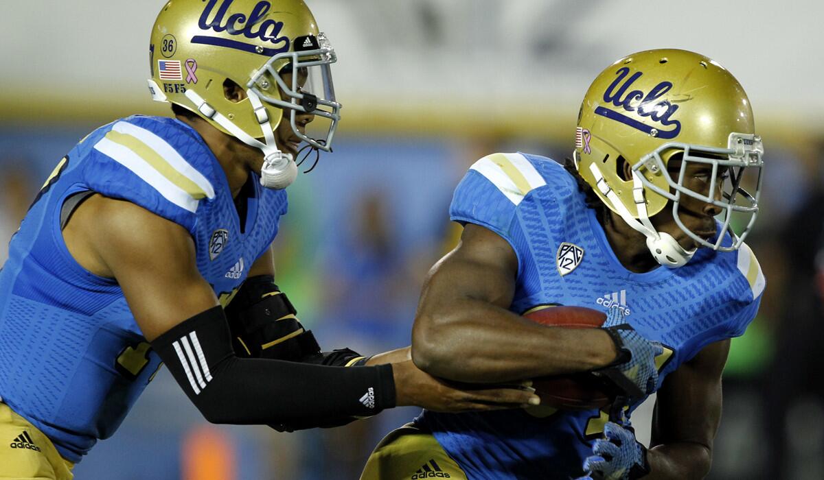 Quarterback Brett Hundley, left, and running back Paul Perkins will try to help the Bruins beat the high-flying Ducks in a key Pac-12 Conference game on Saturday at the Rose Bowl.