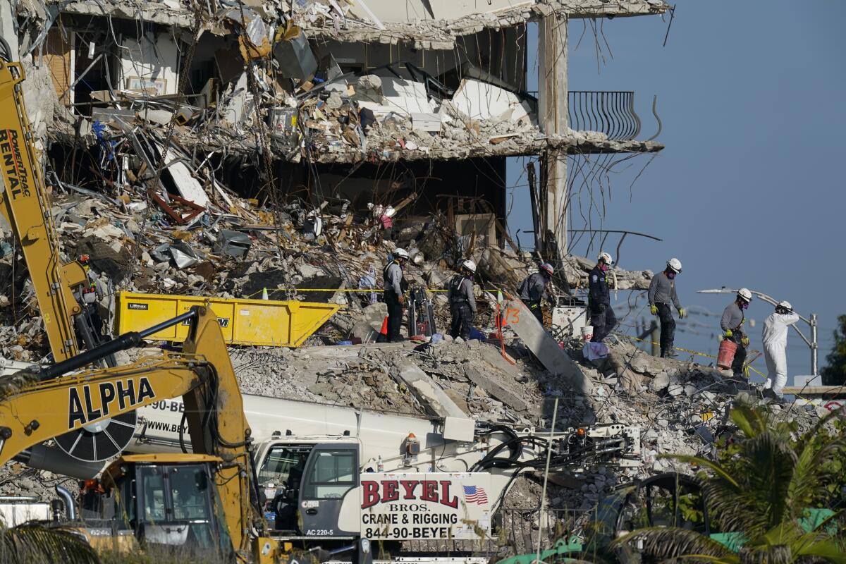 Rubble and rescue workers at site of condo tower collapse