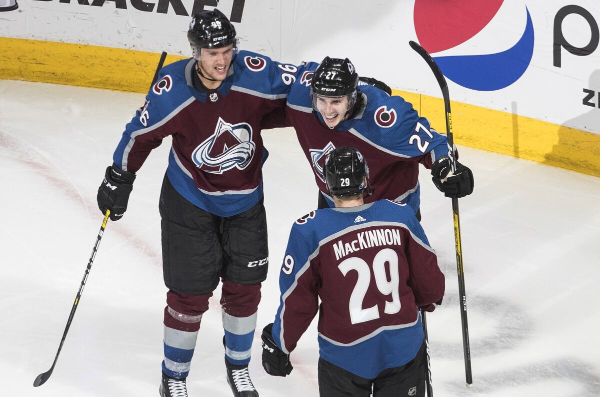 Colorado Avalanche's Mikko Rantanen (96), Ryan Graves (27) and Nathan MacKinnon (29) celebrate a goal against the St. Louis Blues during the third period of an NHL hockey playoff game Sunday, Aug. 2, 2020, in Edmonton, Alberta. (Jason Franson/The Canadian Press via AP)