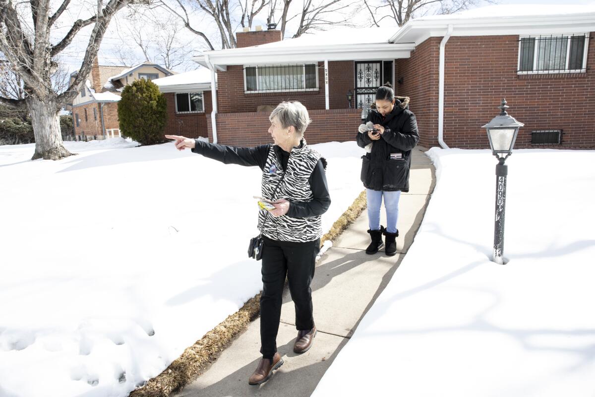 Canvasser Allyson Gottesman points to the next street of voters' homes while Michael R. Bloomberg field organizer Brittany James double-checks their notes in Wheat Ridge, Colo., while canvassing on Saturday.