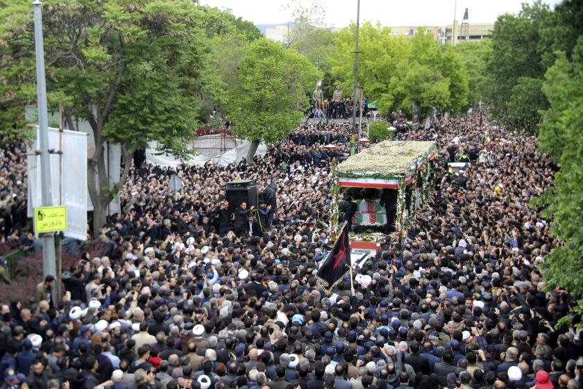 In this photo provided by Fars News Agency, mourners gather around a truck carrying coffins of Iranian President Ebrahim Raisi and his companions who were killed in a helicopter crash on Sunday in a mountainous region of the country's northwest, during a funeral ceremony at the city of Tabriz, Iran, Tuesday, May 21, 2024. Mourners in black began gathering Tuesday for days of funerals and processions for Iran's late president, foreign minister and others killed in a helicopter crash, a government-led series of ceremonies aimed at both honoring the dead and projecting strength in an unsettled Middle East. (Ata Dadashi, Fars News Agency via AP)